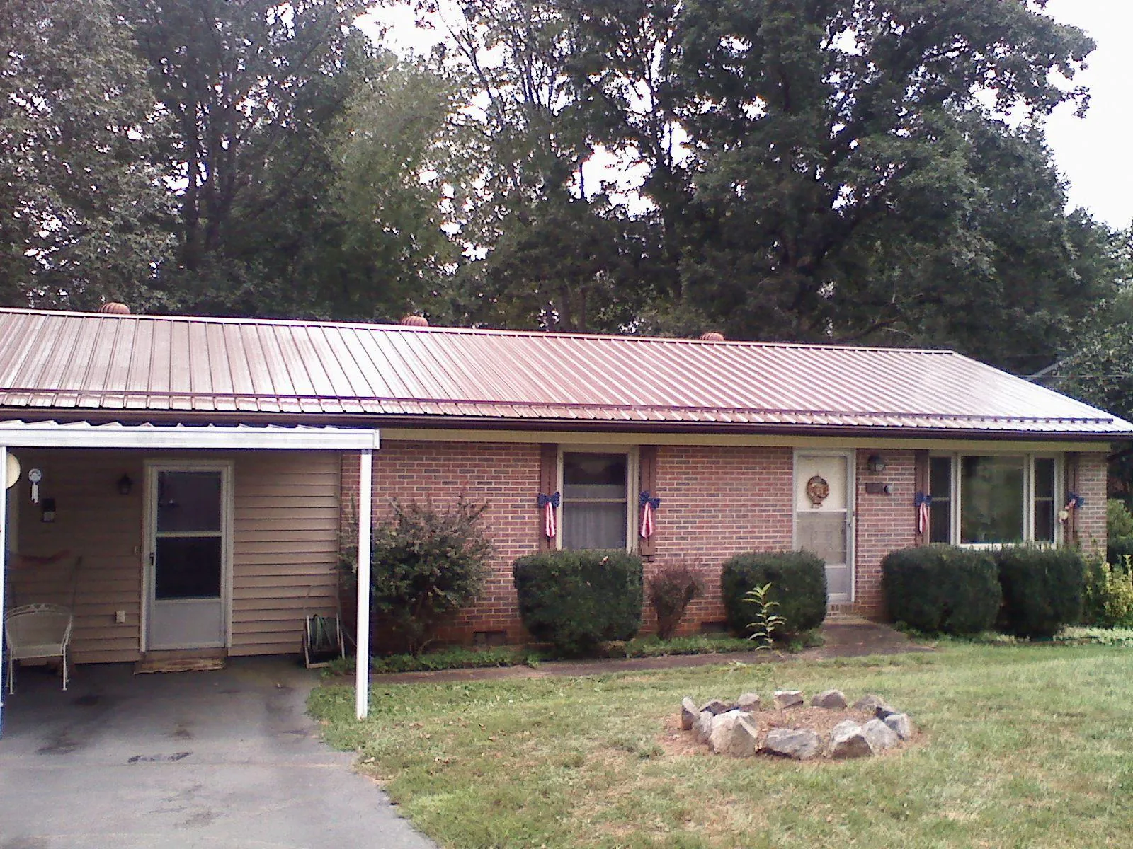 Bronze metal roof and carport on a brick ranch home — Roof Repair work by our crew in Bunker Hill